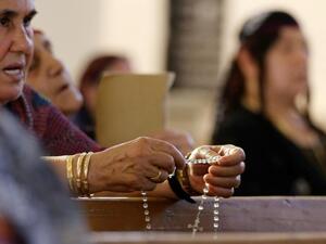 Christian women from outside Mosul pray at a church in Erbil, the capital of Iraqi Kurdistan. (AFP/Karim Sahib)