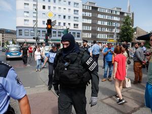 A policeman of a special unit wears protective clothing as he walks through Berlin's Schoeneberg district, where a man was arrested after a suspicious car was found shortly before an event to celebrate the 100th birthday of former US President John F Kennedy, on May 29, 2017. (AFP/Odd Andersen)