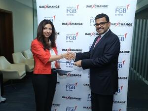 Hana Rostamani, Head of Consumer Banking, FGB and Promoth Manghat, CEO, UAE Exchange exchanging signed agreement