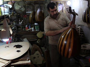 Musician and artisan Ali Mohammed Abdali makes an oud at his workshop on Baghdad's Rashid Street. (AFP/File)