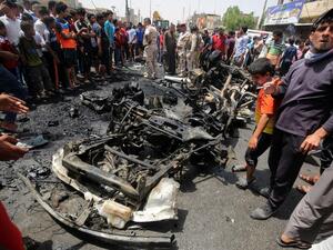 Iraqis look at the damage following a car bomb attack in Sadr City, a Shiite area north of the capital Baghdad, on May 11, 2016. (AFP/Ahmad al-Rubaye)