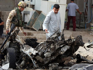Iraqi troops inspect the scene of a car bomb explosion in Baghdad. (AFP/File)