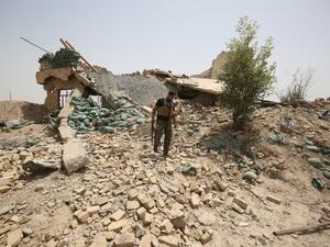 A member of the Iraqi government forces walks amid the rubble of a destroyed building on the front line near the village of al-Azraqiyah, northwest of the city of Fallujah, on June 5, 2016. (AFP/Ahmad al-Rubaye)