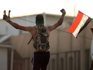An Iraqi protestor waves fire bombs during a protest outside the regional government headquarters in the southern city of Basra on September 5, 2018. (Haidar MOHAMMED ALI / AFP)