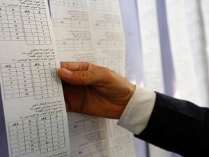 An Iraqi electoral commission official examines electronic counting machine print-outs in Najaf on May 13, 2018. (Haidar Hamdani | AFP)