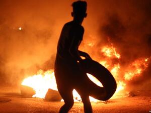 A demonstrator burns tires during protests in the southern Iraqi city of Basra on July 12. (AFP/File)