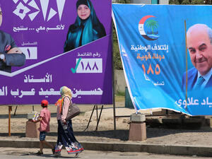 People walk past campaign posters of former Prime Minister Eyad Allawi and other candidates ahead of the upcoming parliamentary elections in Iraq. (AFP/ File Photo)