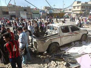 Iraqis stand at the site of a car bomb explosion in the Shiite-majority Sadr City area of north Baghdad on March 23, 2015. (AFP/File)