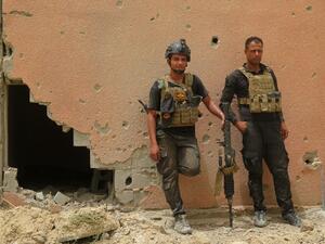 Iraqi counter-terrorism forces lean against a wall riddled with bullet holes in Fallujah. (AFP/Jean Marc Mojon)