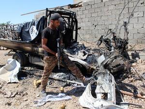 A member of Iraqi forces examines a burnt car with a Daesh flag in Hit, in the Anbar province. (AFP/Moadh Al-Dulaimi)