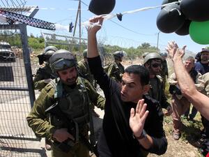 Palestinian protesters are stopped by Israeli soldiers during a protest against settlement expansion on Palestinian land. [vosizneias]
