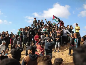 Palestinian protestors wave their national flag during a demonstration near the border with Israel. (AFP/ File Photo)