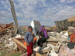 A Palestinian woman and her child check the rubble of their house after it was demolished by Israeli authorities. (AFP/File)