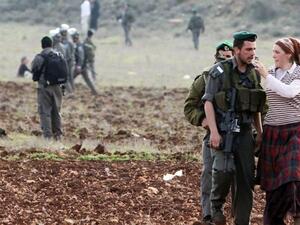 Israeli forces talk with Jewish settlers from the Esh Kodesh outpost as they stage a sit-in to prevent Palestinians from working in their fields, Jan. 2, 2013. (AFP/Jaafar Ashtiyeh)