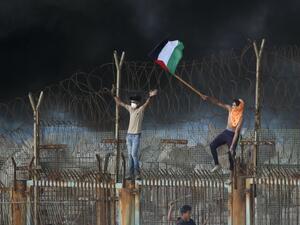 Palestinian protestors place their national flag on a metal structure during a demonstration on the beach near the maritime border with Israel, in the northern Gaza Strip, on October 8, 2018. (Said KHATIB / AFP)
