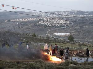 Jewish settlers set tyres ablaze at the Amona outpost, northeast of Ramallah, on February 1, 2017 as Israeli security forces are preparing to evict the hardline occupants of the wildcat settlement outpost. (AFP/Jack Guez)