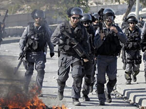 Israeli security officers run past burning tires during clashes with Palestinian protesters in the Issawiya district of Arab east Jerusalem on October 24, 2014. (AFP/ Ahmad Gharabli) 