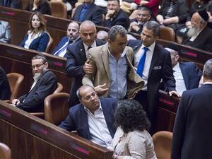 Palestinian lawmaker Jamal Zahalka is escorted to leave after he reacted to Prime Minister Benjamin Netanyahu’s speech on May 14, 2015 at the Knesset. (AFP)