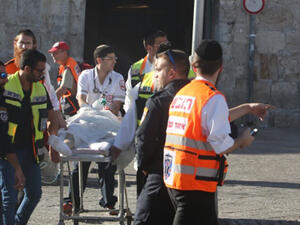 Israeli medics carry an injured man following a Palestinian stabbing attack near the Herod's Gate entrance to the Old City of Jerusalem. (Menahem Kahana/AFP)