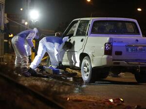 Israeli forensic policemen inspect the body of a Palestinian man who drove at a bus stop in an attempted car-ramming attack before being shot dead, east of Ramallah, on January 25, 2017. (AFP/Ahmad Gharabli)