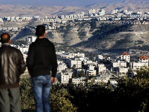 Two men observe the Israeli settlement of Maale Adumim in the Palestinian West Bank from Jerusalem on January 23, 2017. (AFP/Thomas Coex)