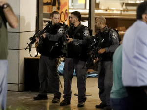 Israeli security forces gather outside the Sarona shopping complex after a shooting attack on June 8, 2016. (AFP/Jack Guez)