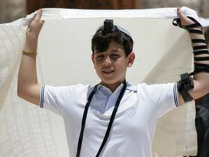 A boy in tradition Jewish dress gets ready for prayer (Pixabay)