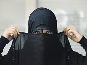 A woman puts on a Niqab, an act now illegal in the Swiss province of Ticino (Shutterstock)