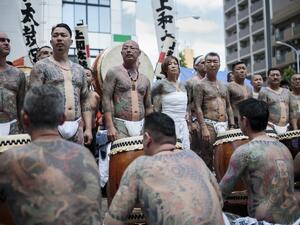 Participants pose to show their traditional Japanese tattoos (Irezumi), related to the Yakuza, during the annual Sanja Matsuri festival in the Asakusa district of Tokyo /AFP