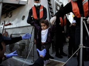 A little girl looks on upon arrival at the northern island of Lesbos after crossing the Aegean sea with other migrants and refugees from Turkey /AFP