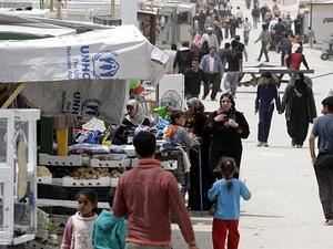Syrian refugees walk past a makeshift market in Zaatari refugee camp in north Jordan. (AFP/Khalil Mazraawi)