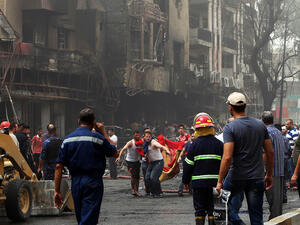 People evacuate victims after the July Daesh attack in Baghdad's Karada district (AFP/File)