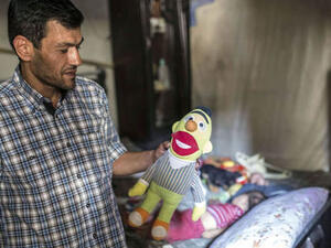 Man hold toys in memory of lost children (AFP/File Photo)	