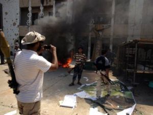 ثوار ليبيون يلتقطون صورا تذكارية في مجمع باب العزيزية في طرابلس