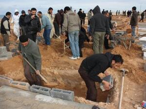 ليبيون يعدون القبور لدفن قتلاهم/أ.ف.ب