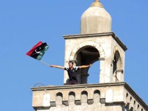 ليبي يرفع علم المعارضة فوق أحد مأذنة مسجد في مدينة الزاوية القريبة من العاصمة طرابلس