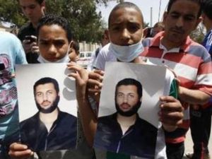 شابان يحملان صورة لسيف العرب القذافي في طرابلس يوم الاحد.
