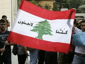 Lebanese protesters hold a Lebanese national flag on which is written in Arabic, "We are all refugees" on July 18, 2016 in the capital Beirut. (AFP/Joseph Eid) Lebanese protesters hold a Lebanese national flag on which is written in Arabic, "We are all refugees" on July 18, 2016 in the capital Beirut. (AFP/Joseph Eid)