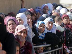 Syrian women wait in Arsal, Lebanon. (AFP/File)