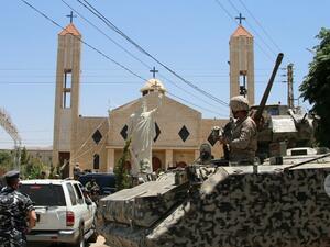Lebanese soldiers stand guard in front of a church where a suicide bomber blew himself up the previous day in the Christian village of al-Qaa, near the Lebanon's border with Syria, on June 28, 2016. (AFP/Stringer)