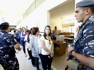 Lebanese security forces stand guard as women stand in line to cast their vote for the municipal elections at a polling station on May 8, 2016 in the capital Beirut. (AFP/Anwar Amro)