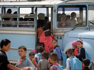 Syrian refugee children prepare to board a school bus at an unofficial refugee camp in Lebanon's town of Bar Elias in the Bekaa Valley on May 13, 2016. (AFP/Joseph Eid)