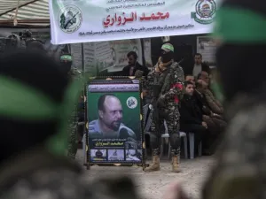 Members of Hamas' military wing hold a banner bearing a portrait of Mohamed Zaouari, who was murdered in Tunisia (AFP/File Photo)