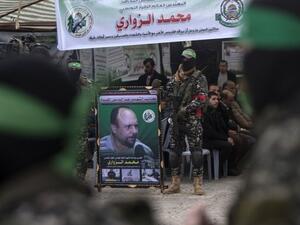 Members of Hamas' military wing hold a banner bearing a portrait of Mohamed Zaouari, who was murdered in Tunisia (AFP/File Photo)