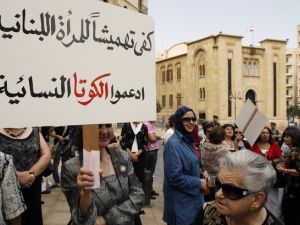 An activist carries a banner that reads 'Enough marginalisation of Lebanese women, support the feminine quota" during a sit-in outside the Lebanese parliament in downtown Beirut. (AFP/ File Photo)