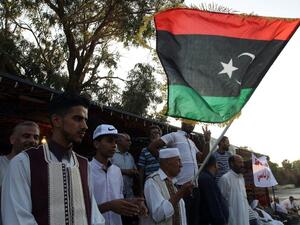 A Libyan protestor waves his national flag during a demonstration in Benghazi in support of General Khalifa al-Haftar, who is aligned with the elected House of Representatives in the eastern city of Tobruk and against the rival UN-backed Government of National Accord (GNA) based in the capital Tripoli and foreign intervention in Libya on August 5, 2016. (AFP/Abdullah Doma)