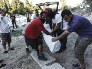 Men bury an unknown Syrian refugee on Lesbos. (AFP/Achilleas Zavallis)