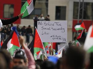 Palestinians wave national flags as they take part in a protest against a social security law proposed by the Palestinian Authority in the West Bank city of Ramallah on November 12, 2018. (ABBAS MOMANI / AFP)
