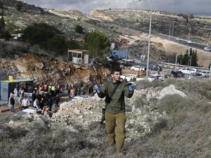 Israeli forces and forensic experts inspect the site of a Palestinian drive-by shooting attack outside the West Bank settlement of Givat Asaf, northeast of Ramallah, on December 13, 2018. (AFP)