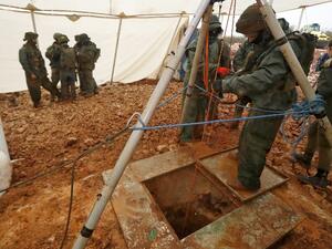 An Israeli soldier operating a pulley while standing outside an entry point made by the army to intercept a tunnel which reportedly connects between Lebanon and Israel, near the border. (AFP/File)